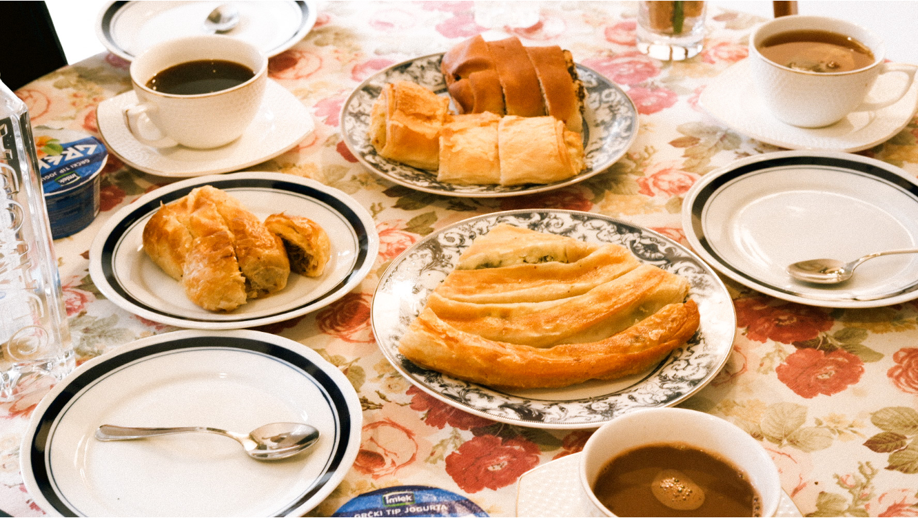 花柄のテーブルクロスに並ぶ朝食とコーヒー